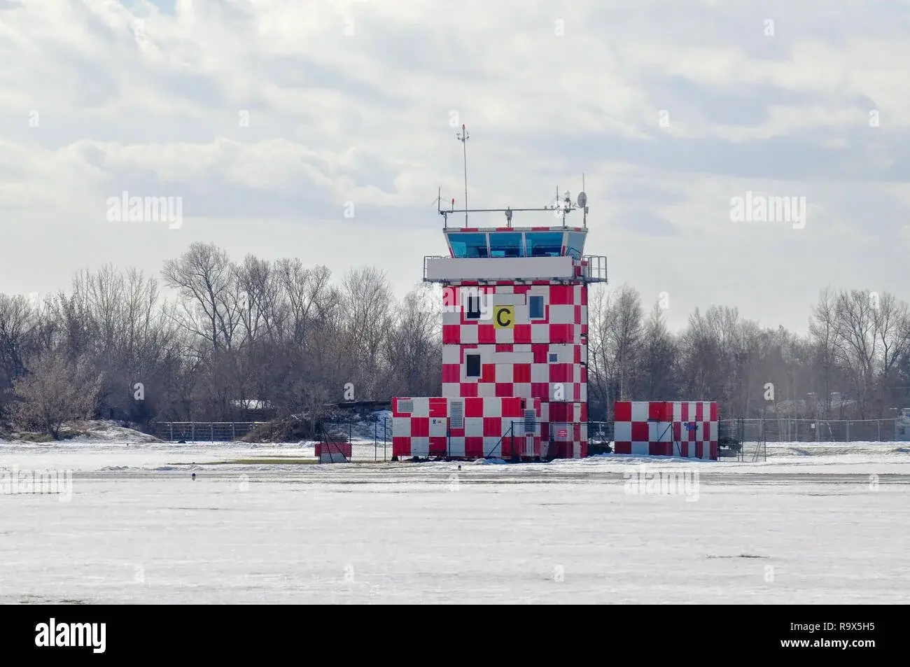 red-and-white-checkered-airport-control-tower-in-winter-copyspace-nobody-R9X5H5.webp