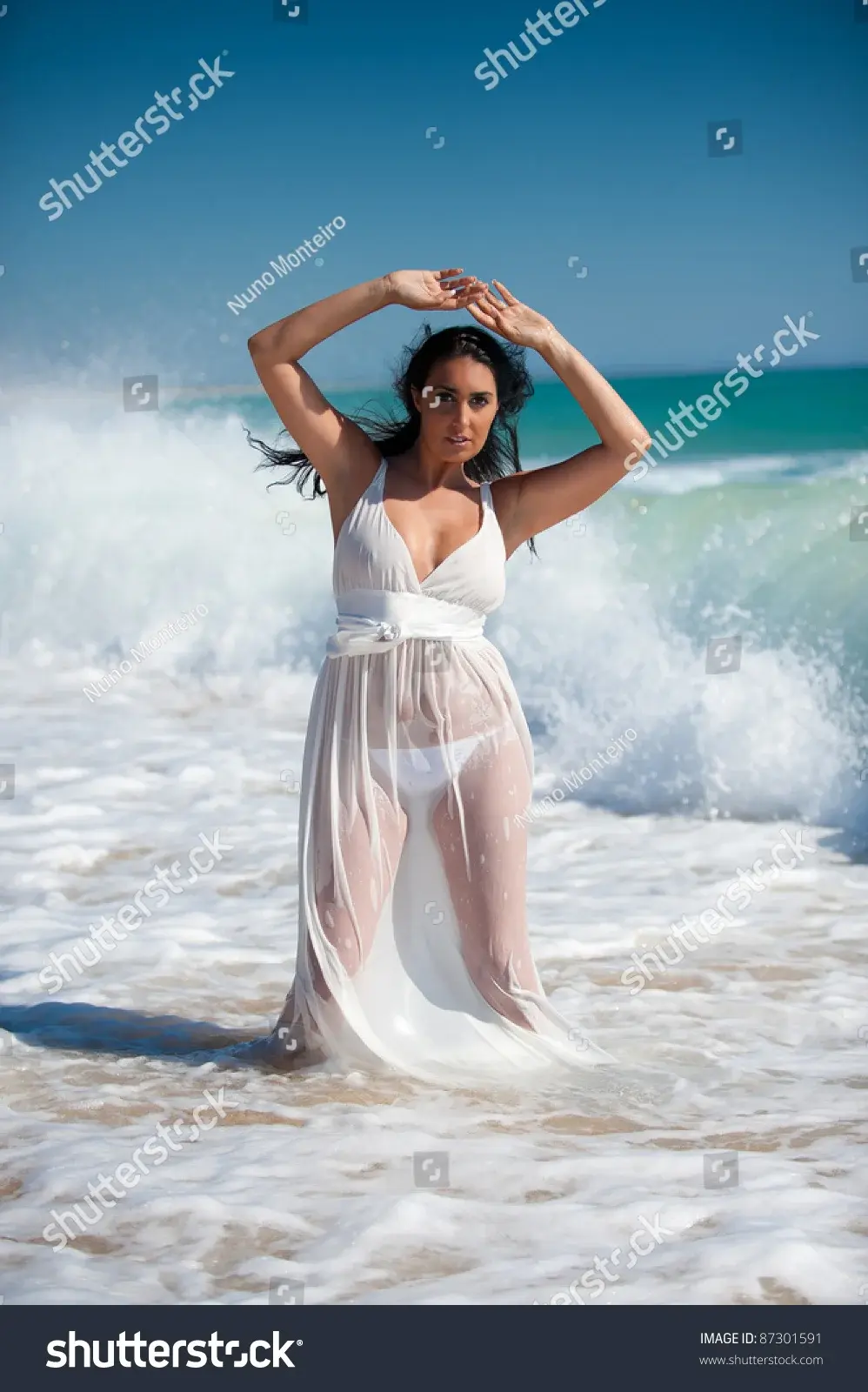 stock-photo-brunette-woman-with-a-white-transparent-and-wet-dress-at-the-beach-on-the-water-p...webp