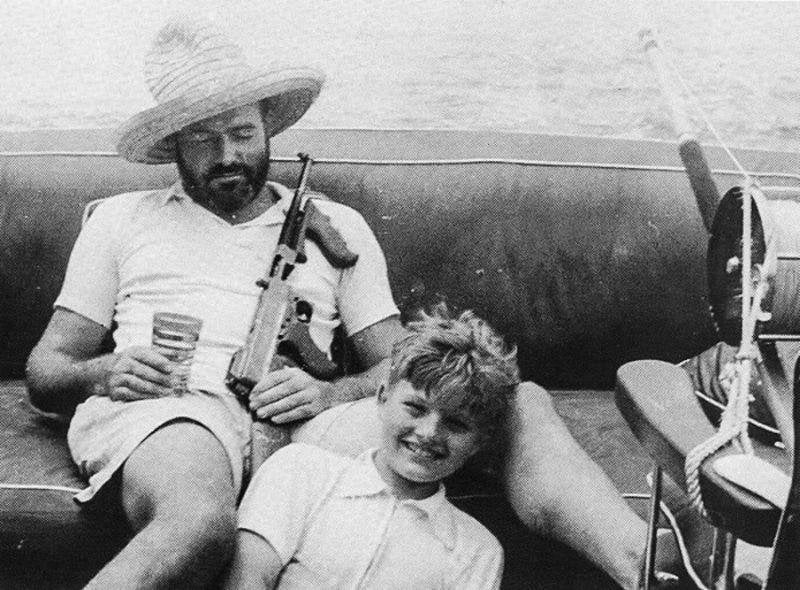 Hemingway drunk on boat with full auto thompson and child.jpg