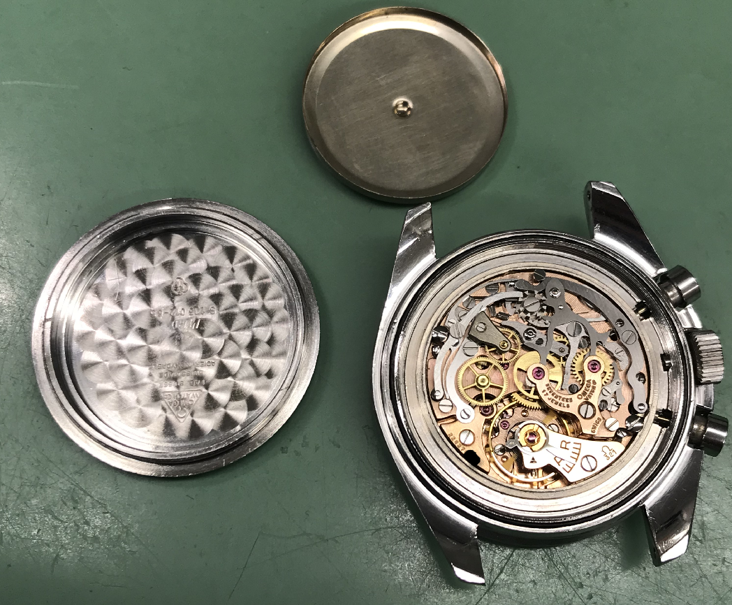 Bagkasse og åbent urværk.png